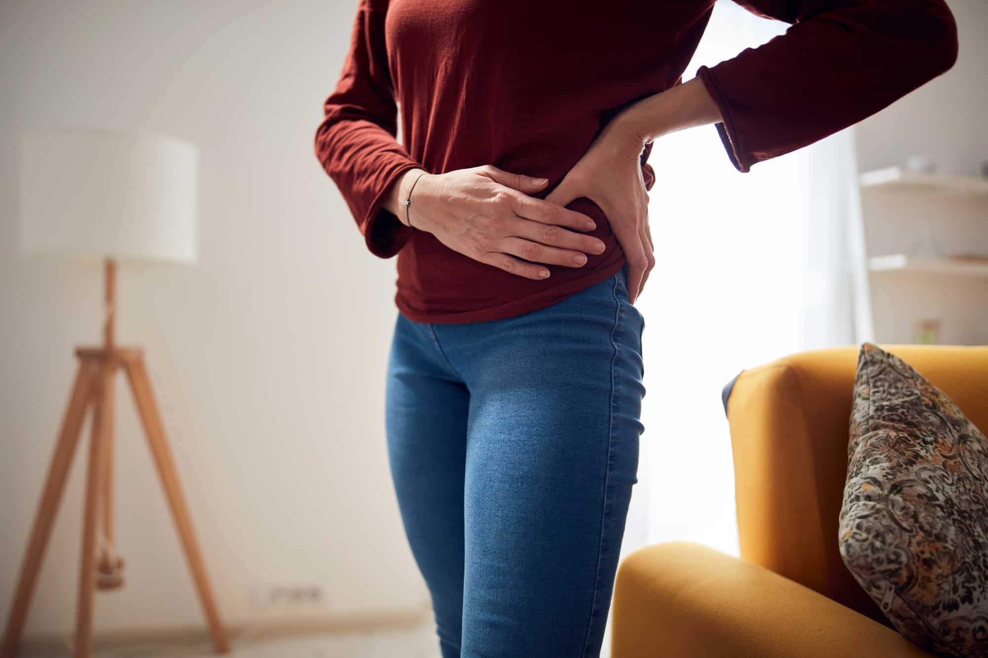 Woman with strong hip pain at home.