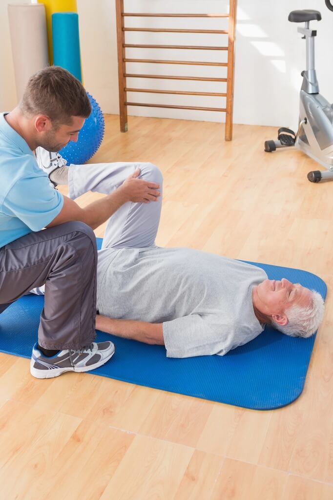 Senior man with physical therapist